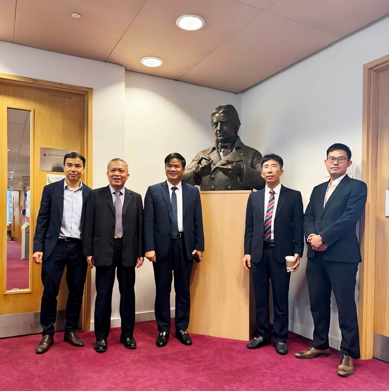 A group of men standing in front of a wall with a statue of a person

AI-generated content may be incorrect.